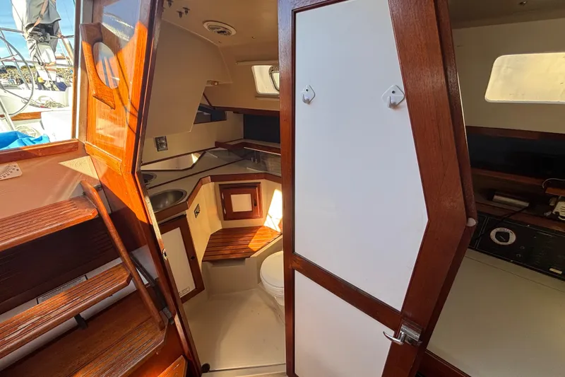 Slide: The Image of Interior of a 1988 Catalina 34 sailboat, featuring wooden cabinetry and compact design. - 18
