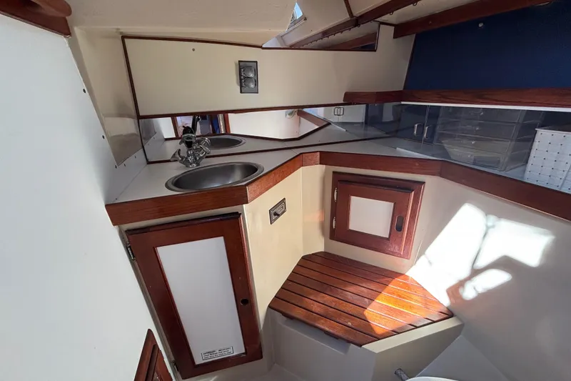 Slide: The Image of Interior of 1988 Catalina 34 sailboat with compact kitchen and wooden accents. - 21