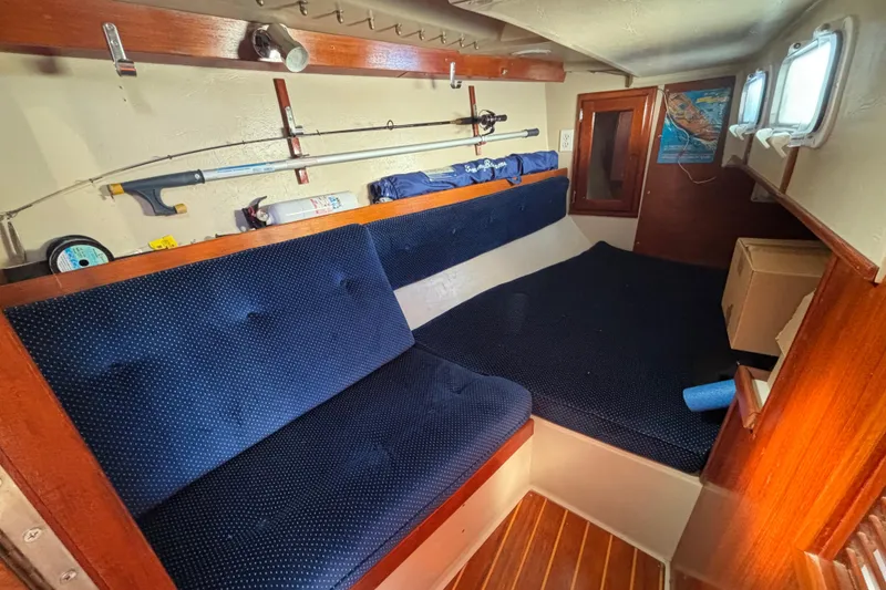 Slide: The Image of 1988 Catalina 34 sailboat interior with blue cushions and wooden accents. - 23