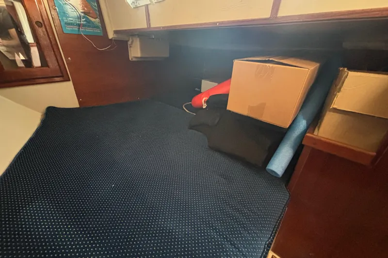 Slide: The Image of Interior cabin of 1988 Catalina 34 sailboat with storage boxes and blue mat. - 24