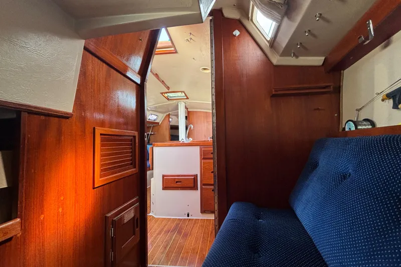 Slide: The Image of Interior of a 1988 Catalina 34 sailboat with wood paneling and blue upholstery. - 25