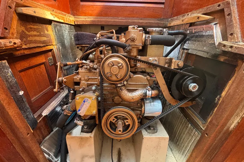 Slide: The Image of Engine of a 1988 Catalina 34 sailboat, showcasing mechanical components and belts. - 27