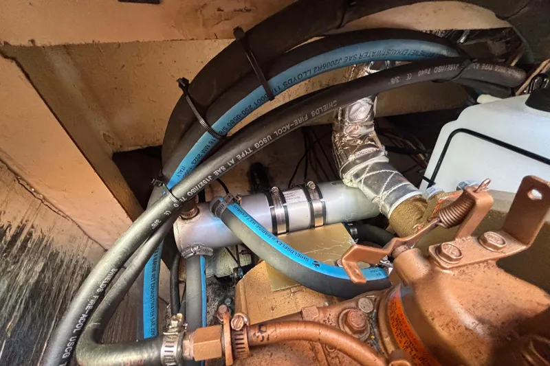 Slide: The Image of Engine compartment of a 1988 Catalina 34 sailboat with hoses and fittings. - 29