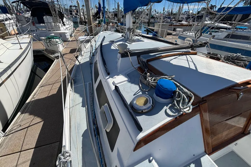 Slide: The Image of 1988 Catalina 34 sailboat docked, featuring deck details and rigging in a marina setting. - 36