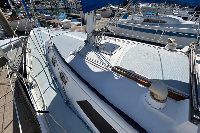 Slide: The Image of 1988 Catalina 34 sailboat docked at marina, showcasing deck and rigging. - 37