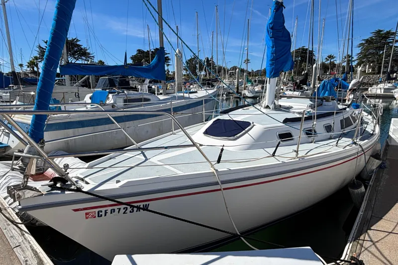 Slide: The Image of 1988 Catalina 34 sailboat docked in a marina, featuring blue sails and a sleek design. - 39