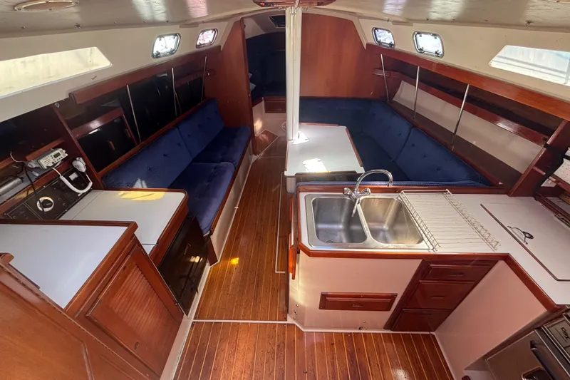 Slide: The Image of Interior of a 1988 Catalina 34 sailboat with wood finish and blue seating. - 4