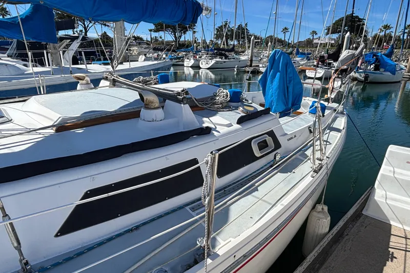 Slide: The Image of 1988 Catalina 34 sailboat docked in a marina, surrounded by other boats. - 42