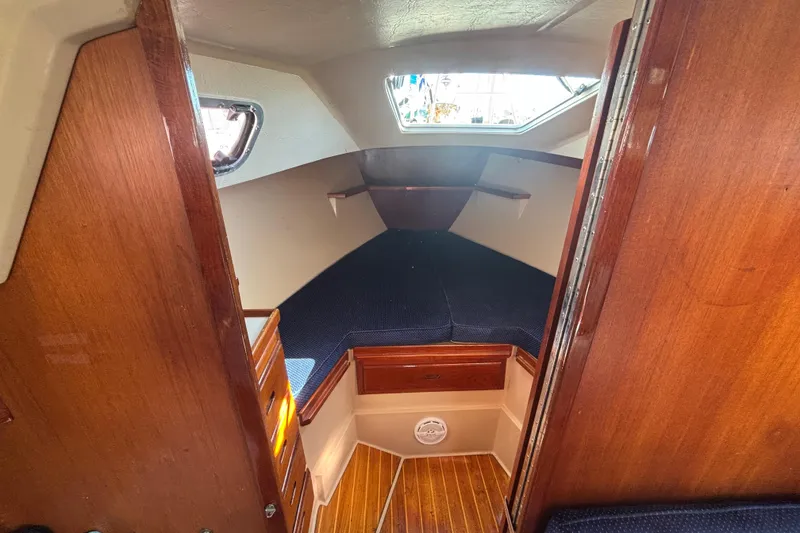 Slide: The Image of Interior cabin of a 1988 Catalina 34 sailboat with wood finish and cozy sleeping area. - 9