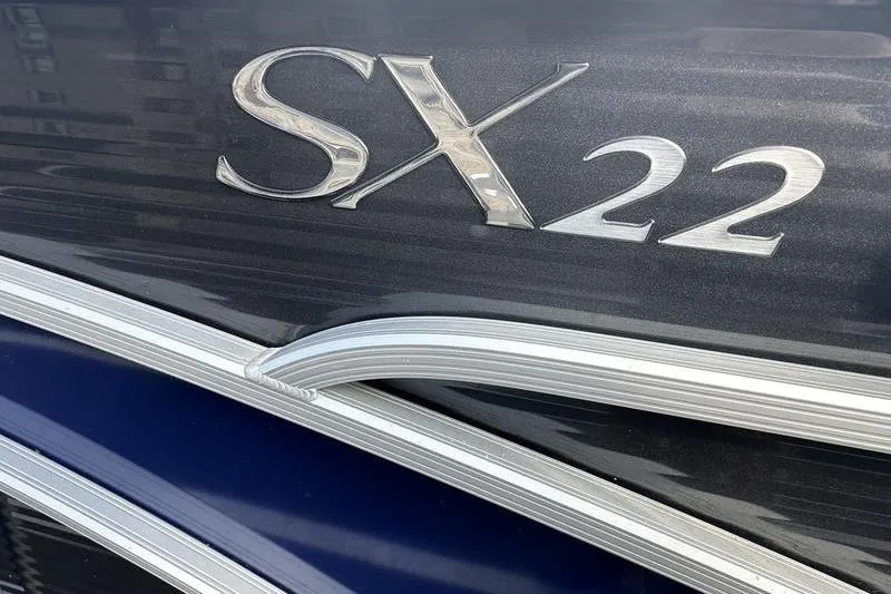 Slide: The Image of Close-up of 2023 Bennington 22 SX Swingback boat emblem, featuring SX22 lettering. - 12