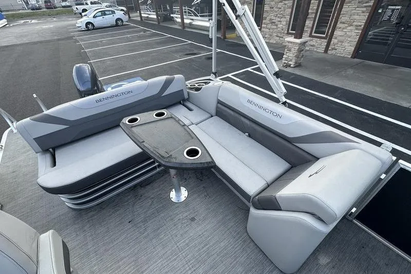 Slide: The Image of 2023 Bennington 22 SX Swingback boat interior with gray seating and table. - 20