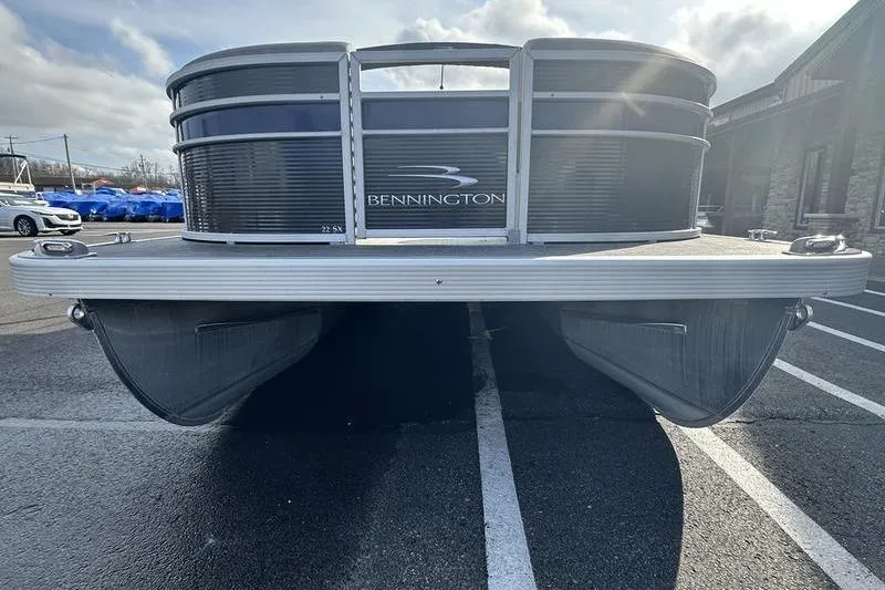Slide: The Image of 2023 Bennington 22 SX Swingback pontoon boat, front view in parking lot. - 3