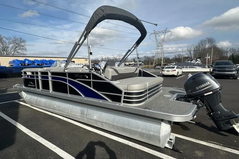 Slide: The Image of 2023 Bennington 22 SX Swingback pontoon boat with Yamaha outboard, parked in a lot. - 9