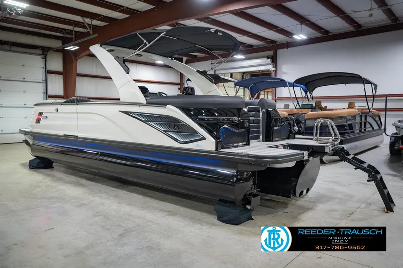 Slide: The Image of 2026 Bennington QX 25 QXFBA pontoon boat in showroom, featuring sleek design and modern amenities. - 10