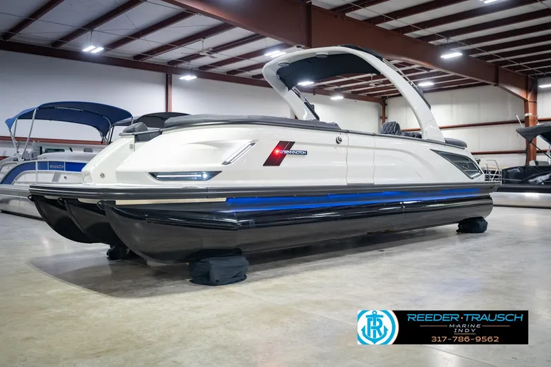 Slide: The Image of 2026 Bennington QX 25 QXFBA pontoon boat in showroom, side view. - 3