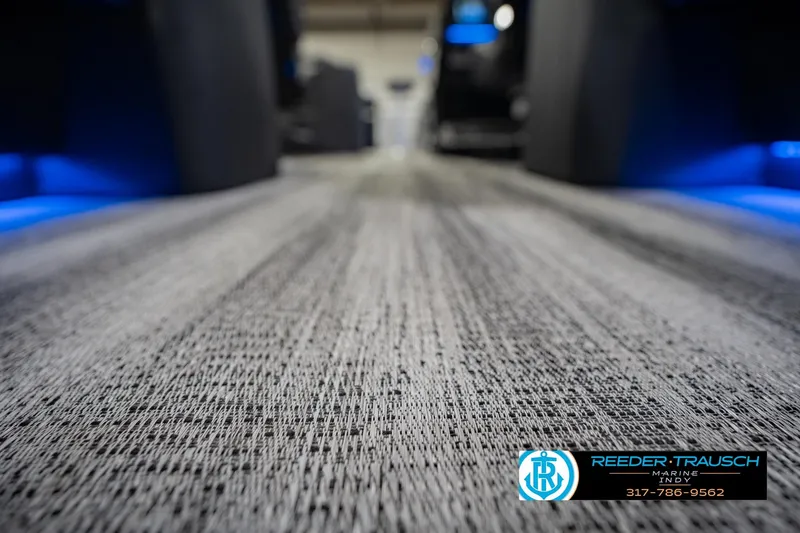Slide: The Image of Carpeted interior of 2026 Bennington QX 25 QXFBA boat with blue ambient lighting. - 45
