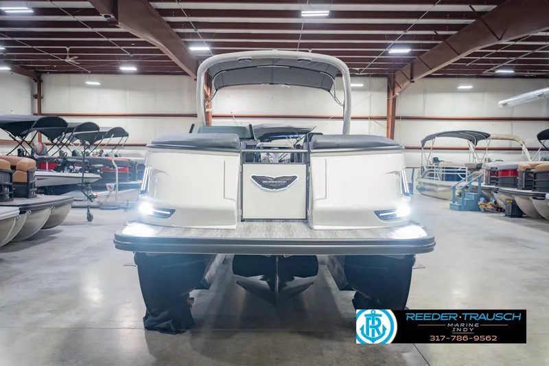 Slide: The Image of 2026 Bennington QX 25 QXFBA pontoon boat in showroom, rear view with lights on. - 5