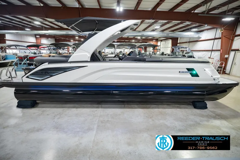 Slide: The Image of 2026 Bennington QX 25 QXFBA pontoon boat in showroom, side view. - 7