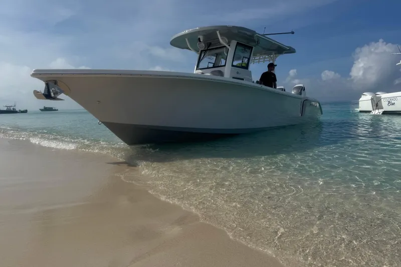 Slide: The Image of 2024 Sea Pro 322 Offshore boat on clear beach waters under blue sky. - 13