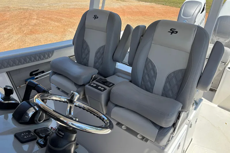 Slide: The Image of 2024 Sea Pro 322 Offshore boat interior with dual gray captain seats and steering wheel. - 29
