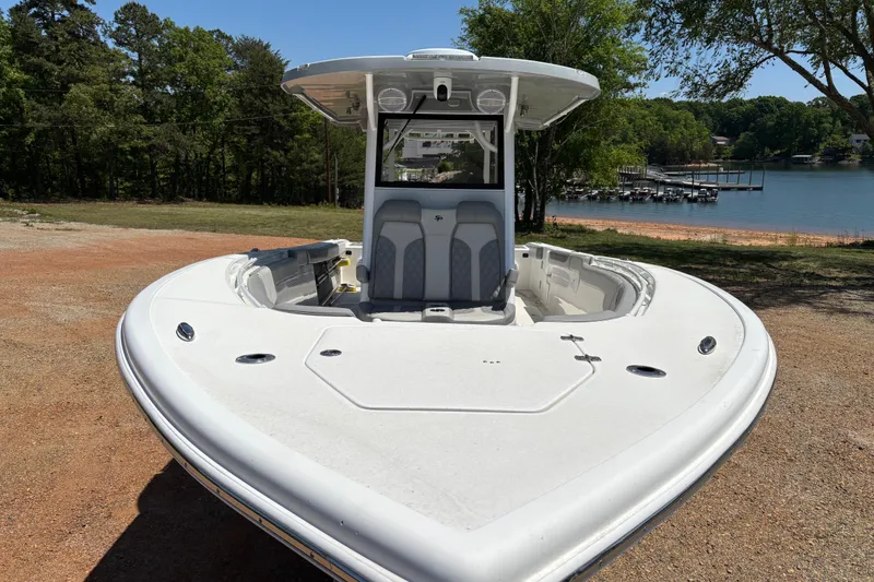 Slide: The Image of 2024 Sea Pro 322 Offshore boat on shore, near a scenic lake backdrop. - 4