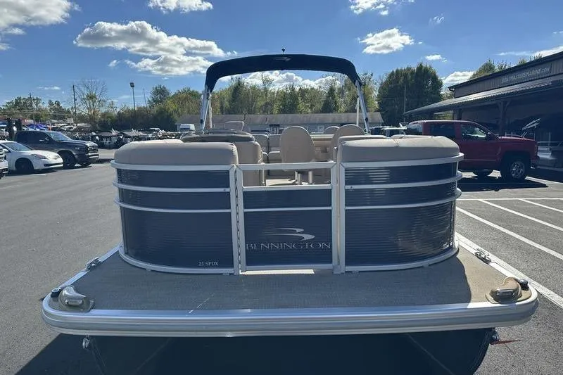 Slide: The Image of 2018 Bennington 23 SPDX pontoon boat in parking lot, sunny day, clear sky. - 10