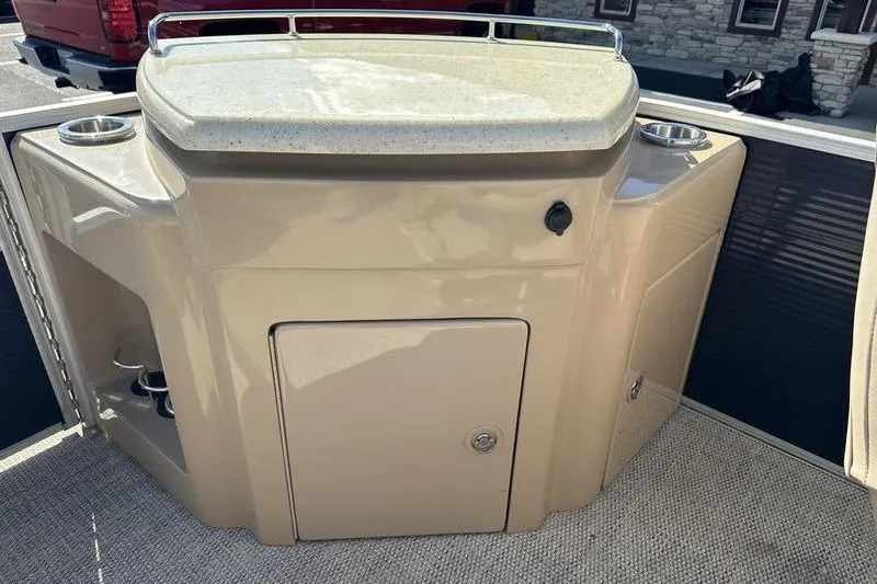 Slide: The Image of 2018 Bennington 23 SPDX boat interior with beige console and storage compartment. - 24