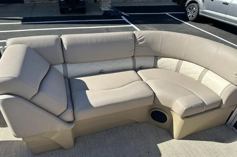 Slide: The Image of 2018 Bennington 23 SPDX boat seating with beige upholstery in a parking lot. - 5
