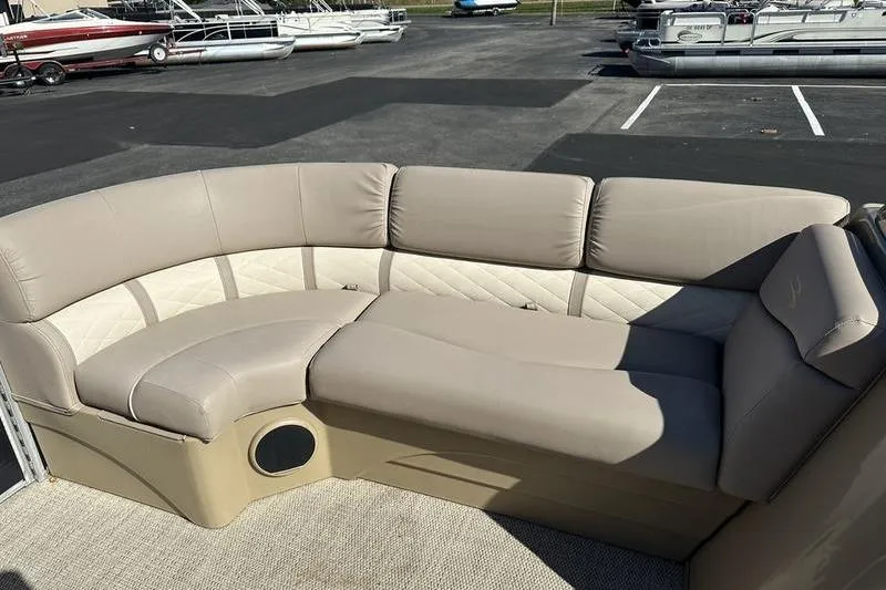 Slide: The Image of 2018 Bennington 23 SPDX pontoon boat with beige seating in a parking lot. - 8