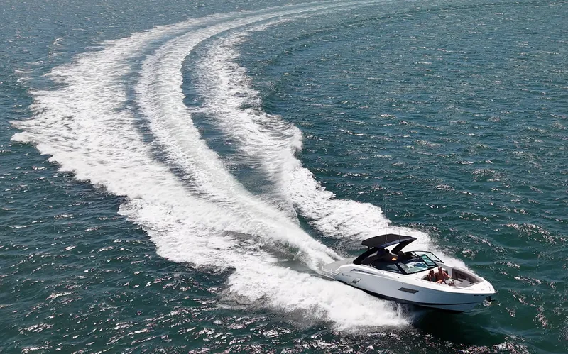 Slide: The Image of A sleek motorboat creates a white wake on blue water as it makes a turn. - 1