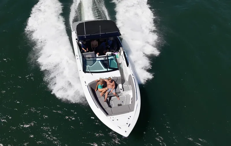 Slide: The Image of A white motorboat with a black canopy speeds across the water. Two people relax on the foredeck. - 7
