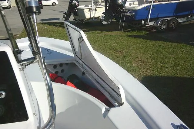 Slide: The Image of 2017 Sportsman Masters 207 Bay Boat with open storage compartment, parked on grass. - 16