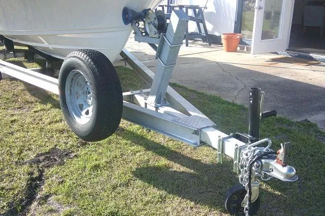 Slide: The Image of 2017 Sportsman Masters 207 Bay Boat trailer on grass, showcasing hitch and wheel. - 3