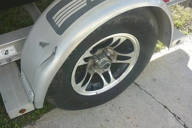 Slide: The Image of Damaged trailer wheel of 2017 Sportsman Masters 207 Bay Boat on concrete surface. - 6