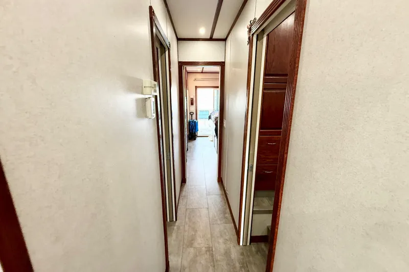 Slide: The Image of Hallway inside 2005 Twin Anchors 6816 Arizona Edition Yacht House, featuring wood trim and tiled floor. - 14