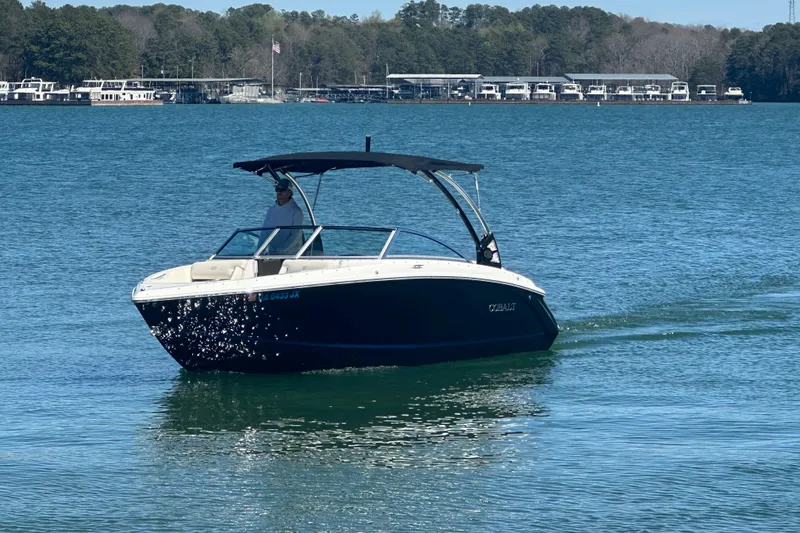 The Image of 2017 Cobalt R3 boat cruising on a serene lake with forested shoreline. - 0