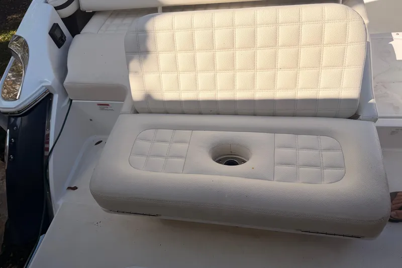 Slide: The Image of White cushioned seating on a 2017 Cobalt R3 boat, featuring a central cup holder. - 12