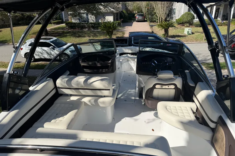 Slide: The Image of 2017 Cobalt R3 boat interior with white seating and steering wheel, parked in residential area. - 15