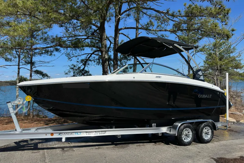 Slide: The Image of 2017 Cobalt R3 boat on trailer by a lake, surrounded by trees. - 2