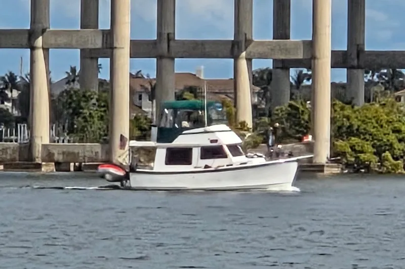 The Image of 1978 Prairie Boat Works 29 Coastal Cruiser navigating under a bridge on a sunny day. - 0