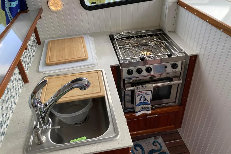 Slide: The Image of Tan leather sofa inside 1978 Prairie Boat Works 29 Coastal Cruiser, with patterned rug. - 16