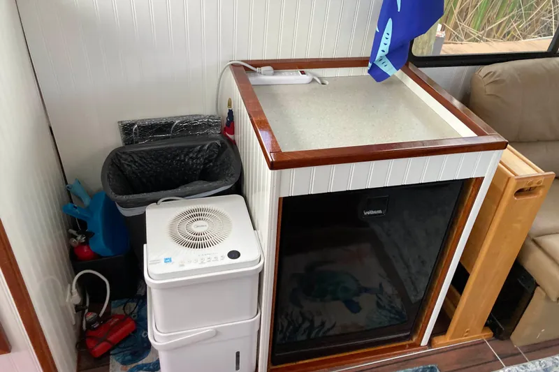 Slide: The Image of Wooden table in 1978 Prairie Boat Works 29 Coastal Cruiser interior, surrounded by beige sofas. - 18