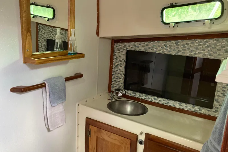 Slide: The Image of Cozy cabin interior of 1978 Prairie Boat Works 29 Coastal Cruiser with nautical-themed bedding. - 25