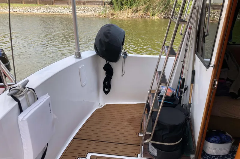 Slide: The Image of 1978 Prairie Boat Works 29 Coastal Cruiser, docked, with green canopy and clear skies. - 9