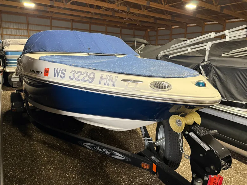 Slide: The Image of 2009 Sea Ray 175 boat with blue cover in storage facility. - 18