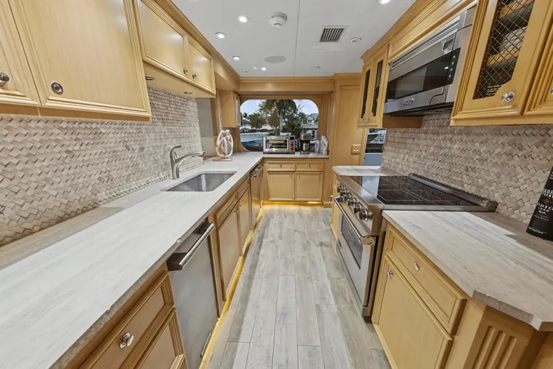 Slide: The Image of Luxurious kitchen in 2002 Ocean Alexander 120 Megayacht with modern appliances and elegant wood cabinetry. - 13