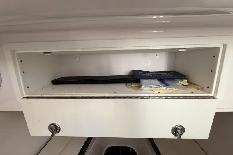 Slide: The Image of Open storage compartment in a 2020 Streamline 45 boat, containing documents and items. - 100
