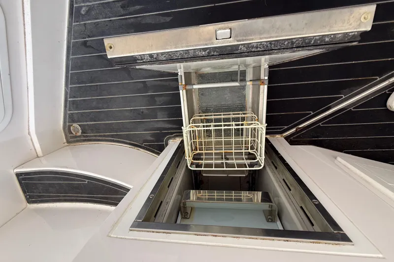Slide: The Image of Open storage compartment on a 2020 Streamline 45 boat, featuring a wire basket. - 104