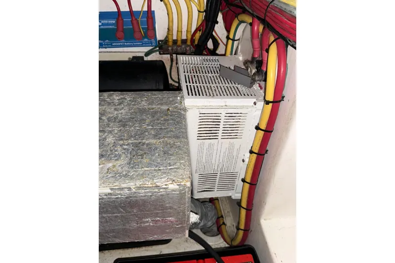 Slide: The Image of Electrical wiring and components inside a 2020 Streamline 45, featuring colorful cables and a battery isolator. - 127