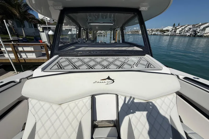 Slide: The Image of 2020 Streamline 45 boat with white seating, docked by waterfront homes. - 22